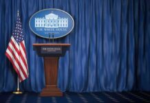 Trump Installs Fighter At The Podium White House press briefing podium with U.S. flag and blue curtain