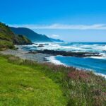 Rocky coastline with blue ocean and grassy cliffs