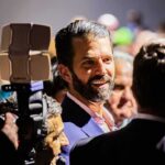 Donald Trump Jr. smiling in a crowd at an event