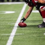 football player setting the ball on the line of scrimmage