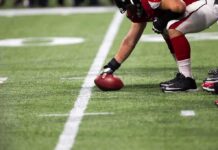 football player setting the ball on the line of scrimmage