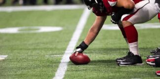 football player setting the ball on the line of scrimmage