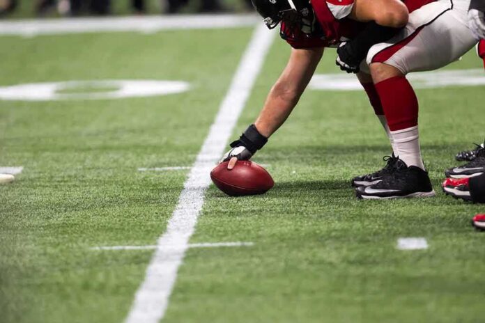 football player setting the ball on the line of scrimmage