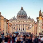 St. Peter's Basilica viewed from a busy street with crowds