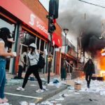 Street protest with fire and smoke outside a bank