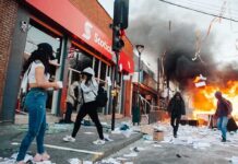 Street protest with fire and smoke outside a bank