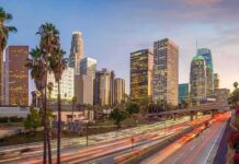 city skyline with palm trees and busy freeway at dusk