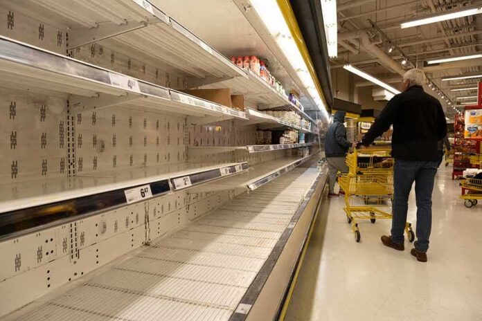 Empty grocery store shelves with shoppers and yellow carts