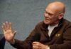 Corruption Superlative Sparks Media Dogfight James Carville speaking into a handheld microphone, gesturing with his left hand