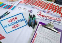 Voter Rolls Tell a Different Political Story Voter registration table with forms, pens, and informational materials