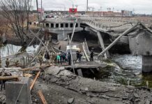 Russia Just Hit One of Kyiv’s Vital Arteries People crossing a destroyed concrete bridge over a river