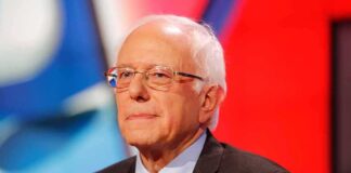 older man in suit and tie on stage