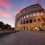 Heritage Under Siege – Cops Clash At Icon Colosseum exterior at sunset with glowing arches