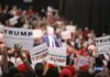 supporters hold signs at a political rally