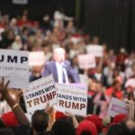 supporters hold signs at a political rally