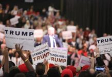 supporters hold signs at a political rally