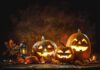 Jack-o'-lantern pumpkins glowing on a rustic table