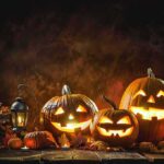 Jack-o'-lantern pumpkins glowing on a rustic table