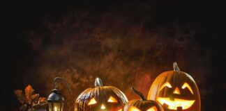 Jack-o'-lantern pumpkins glowing on a rustic table